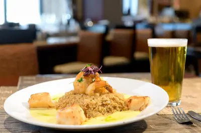 a plate of food on a table with a glass of beer at Sheraton Suites Orlando Airport Hotel in Orlando