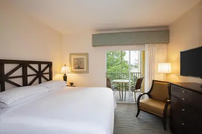 a bedroom with a bed and a chair and a window at Sheraton Vistana Resort Villas, Lake Buena Vista Orlando in Orlando