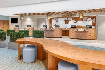a lobby with a reception area with a large wooden table at Sheraton Vistana Resort Villas, Lake Buena Vista Orlando in Orlando