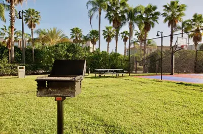 a barbecue grill in a park with palm trees at Vista Cay at Epic Universe - Luxury 4 bedroom condo in Orlando
