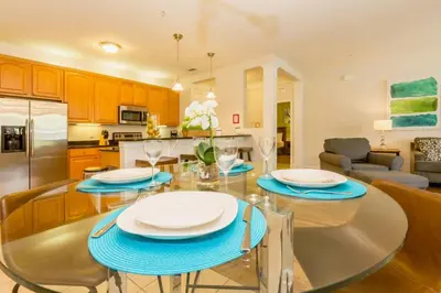 a kitchen and living room with a glass table and chairs at Vista Cay at Epic Universe - Luxury 3 bedroom condo in Orlando