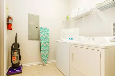 a small kitchen with a washing machine in a room at Vista Cay at Epic Universe - Luxury 3 bedroom condo in Orlando