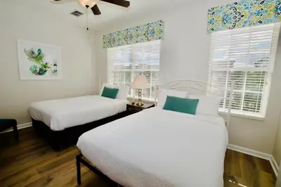 two beds in a room with two windows at Vista Cay at Epic Universe - Luxury 3 bedroom Townhouse in Orlando