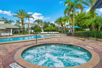 a large pool with a hot tub in a yard with palm trees at Vista Cay at Epic Universe - Luxury 3 bedroom Townhouse in Orlando