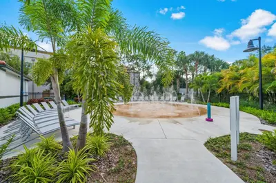 a fountain in a park with a bench and palm trees at Vista Cay at Epic Universe - Luxury 3 bedroom Townhouse in Orlando