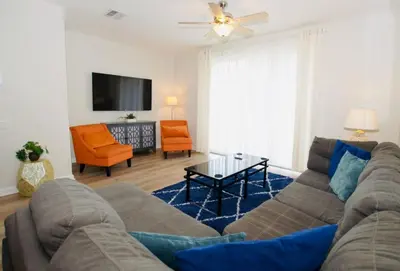 a living room with a couch and a tv at Vista Cay at Epic Universe - Luxury 3 bedroom Townhouse in Orlando