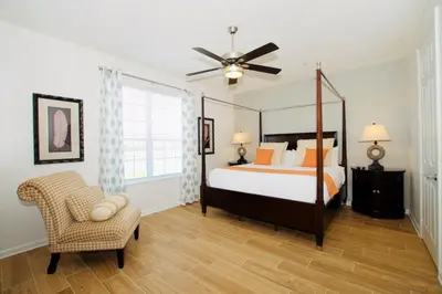 a bedroom with a bed and a fan and a chair at Vista Cay at Epic Universe - Luxury Lakeview 4 bedroom condo in Orlando