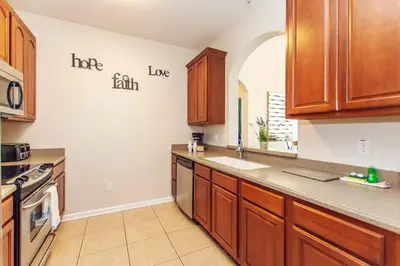 a large kitchen with wooden cabinets and a sink at Vista Cay at Epic Universe - Standard 3 bedroom condo in Orlando