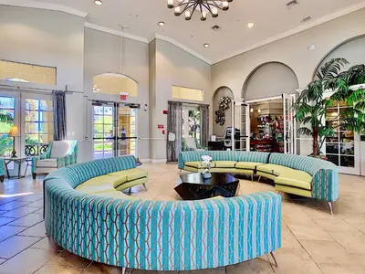 a living room with blue couches and tables at Vista Cay at Epic Universe - Standard 3 bedroom condo in Orlando