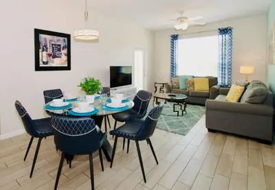 a living room with a table and chairs at Vista Cay at Epic Universe - Standard 3 bedroom condo in Orlando