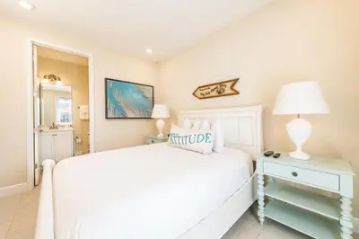 a white bedroom with a white bed and a lamp at Livin' For The Weekend Cottage Near Disney With Margaritaville Resort & Island H2O Access - 8021Ff in Orlando