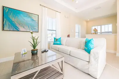 a living room with a white couch and a glass table at Smooth Sailing Cottage With Private Pool Near Disney And Margaritaville Resort & Island H20 Waterpark Access - 7992Sh in Orlando