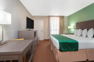 a hotel room with a bed and a flat screen tv at Grand Hotel Orlando at Universal Blvd - Shuttle to Theme Parks in Orlando