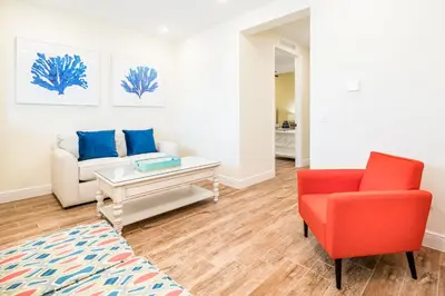 a living room with a couch and a red chair at Tranquil Ocean Blue Cottage Near Disney With Private Pool & Margaritaville Resort & Island H20 Waterpark Access - 3000Ph in Orlando