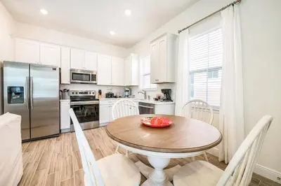 a kitchen with a table and chairs and a refrigerator at Sea Breeze Cottage Near Disney With Private Hot Tub & Margaritaville Resort & Island H20 Waterpark Access - 3016Sr in Orlando