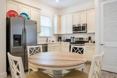 a kitchen with a wooden table and a refrigerator at Premium Cottage With Private Hot Tub Near Disney Margaritaville Resort & Island H2O Access - 3025La in Orlando