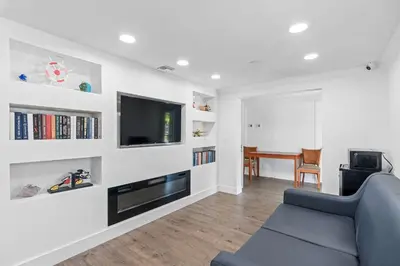 a living room with a blue couch and a tv at Super 8 by Wyndham Kissimmee-Orlando in Kissimmee