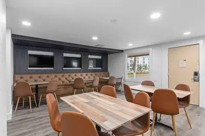 a meeting room with tables and chairs and a tv at Super 8 by Wyndham Kissimmee-Orlando in Kissimmee