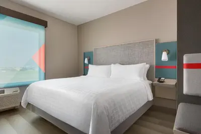 a bedroom with a large white bed and a window at avid hotels - Orlando International Airport by IHG in Orlando