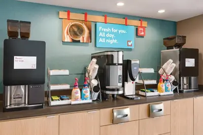 a coffee shop with a counter with a coffee machine at avid hotels - Orlando International Airport by IHG in Orlando