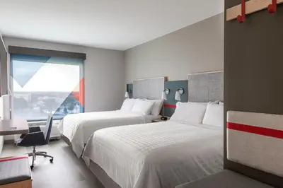 a hotel room with two beds and a window at avid hotels - Orlando International Airport by IHG in Orlando
