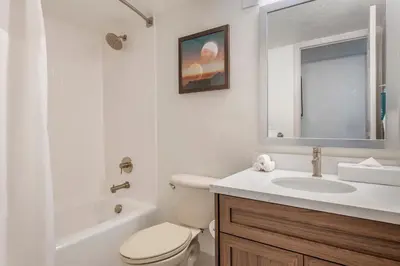 a white bathroom with a toilet and a sink at Orbit One Vacation Villas in Orlando