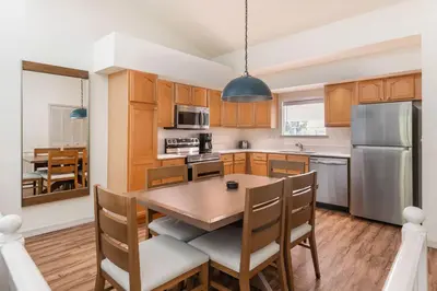 a kitchen with a wooden table and a dining room at Bryan's Spanish Cove in Orlando