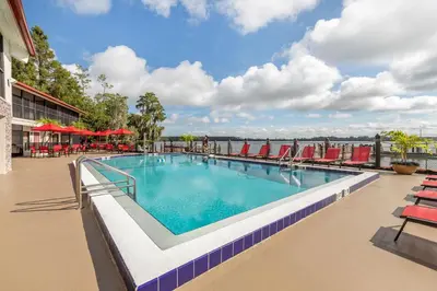 a swimming pool with chairs and a view of the water at Bryan's Spanish Cove in Orlando