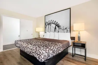 a bedroom with a bed with a large headboard at Super 8 by Wyndham Orlando Near Florida Mall in Orlando