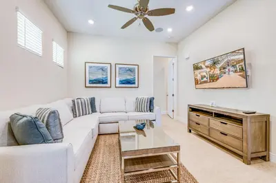 a living room with a white couch and a ceiling fan at Sandy White Cottage Near Disney With Private Hot Tub & Margaritaville Resort & Island H20 Waterpark Access - 3001Sp in Orlando