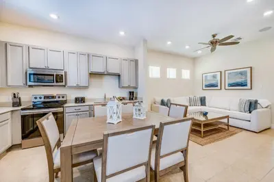 a kitchen and living room with a table and chairs at Sandy White Cottage Near Disney With Private Hot Tub & Margaritaville Resort & Island H20 Waterpark Access - 3001Sp in Orlando