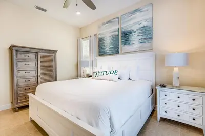 a bedroom with a white bed and a dresser at Sandy White Cottage Near Disney With Private Hot Tub & Margaritaville Resort & Island H20 Waterpark Access - 3001Sp in Orlando