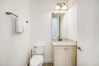 a bathroom with a toilet and a sink and a mirror at Key Lime Cabana Cottage Near Disney With Margaritaville Resort & Island H2O Access - 3062Kl in Orlando