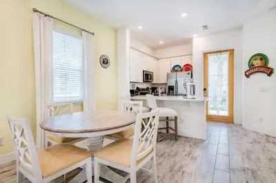 a kitchen and dining room with a table and chairs at Key Lime Cabana Cottage Near Disney With Margaritaville Resort & Island H2O Access - 3062Kl in Orlando