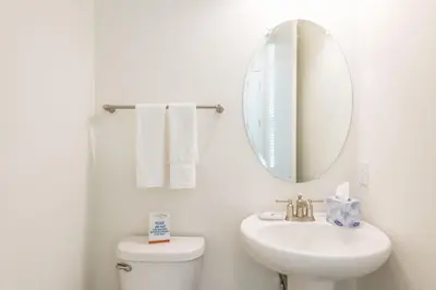 a white bathroom with a sink and a mirror at Playa Verde Cottage With Private Hot Tub Near Disney With Margaritaville Resort & Island H2O Access - 8028Dr in Orlando