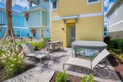 a patio with a table and chairs and a fish tank at Sun Baked Cottage With Hot Tub Near Disney With Margaritaville Resort & Island H2O Access - 8089Dr in Orlando