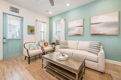 a living room with a couch and a table at Sun Baked Cottage With Hot Tub Near Disney With Margaritaville Resort & Island H2O Access - 8089Dr in Orlando
