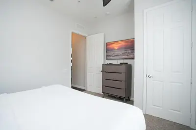 a white bedroom with a white bed and a dresser at 2-403 Your Vista Cay Condo in Orlando
