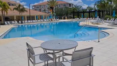 a swimming pool with a table and chairs in a resort at 2-403 Your Vista Cay Condo in Orlando