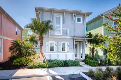 a house with a palm tree in front of it at Sandy Cottage! 3 Miles From Disney With Margaritaville Resort & Island H2O Access - 8080Dr in Orlando