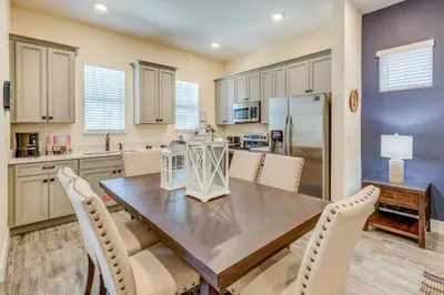 a kitchen and dining room with a wooden table and chairs at Sandy Cottage! 3 Miles From Disney With Margaritaville Resort & Island H2O Access - 8080Dr in Orlando