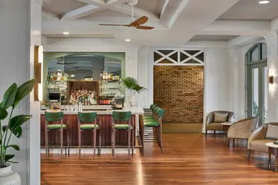 a bar in a room with green stools at The Inn at Celebration, Autograph Collection in Orlando