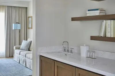 a kitchen with a sink and a living room at The Inn at Celebration, Autograph Collection in Orlando