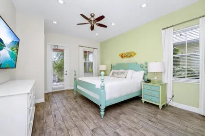 a bedroom with a blue bed and a ceiling fan at Teenie Bikini Cottage With Private Hot Tub Near Disney With Margaritaville Resort & Island H2O Access - 3071Kl in Orlando