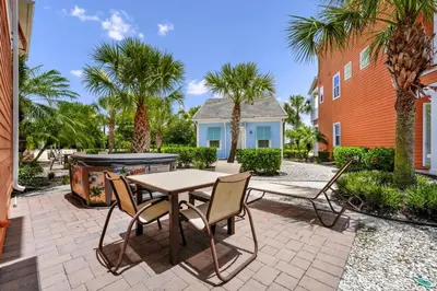a patio with a table and chairs and palm trees at Teenie Bikini Cottage With Private Hot Tub Near Disney With Margaritaville Resort & Island H2O Access - 3071Kl in Orlando