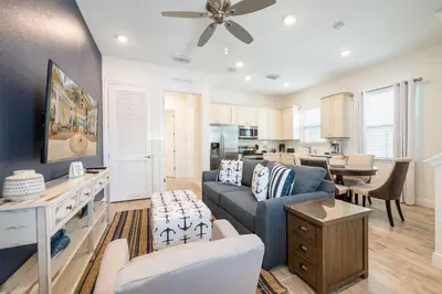 a living room with a couch and a table at Island Life Cottage Near Disney With Margaritaville Resort & Island H2O Access - 8026Su in Orlando