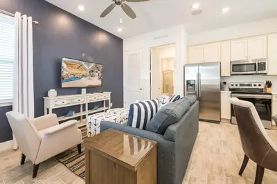a living room with a couch and a table at Island Life Cottage Near Disney With Margaritaville Resort & Island H2O Access - 8026Su in Orlando