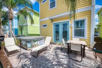 a patio with a table and chairs next to a house at Another Day In Paradise Cottage With Private Hot Tub Near Disney With Margaritaville Resort & Island H2O Access - 8024Dr in Orlando