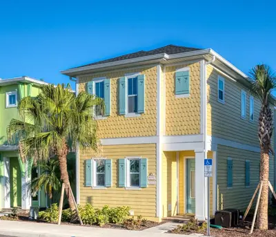 a yellow house with palm trees in front of it at Another Day In Paradise Cottage With Private Hot Tub Near Disney With Margaritaville Resort & Island H2O Access - 8024Dr in Orlando