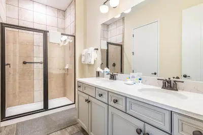 a bathroom with a double sink and a shower at Breezy Cottage With Hot Tub Near Disney With Margaritaville Resort & Island H2O Access - 8069Dr in Orlando